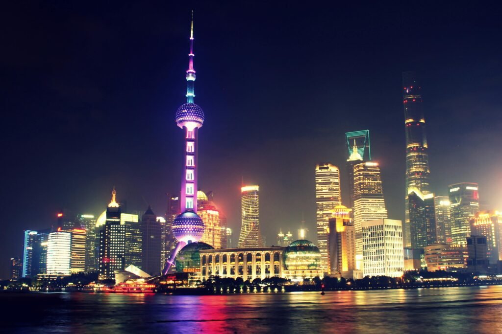 Vibrant nighttime view of Shanghai's iconic skyline featuring the illuminated Oriental Pearl Tower.