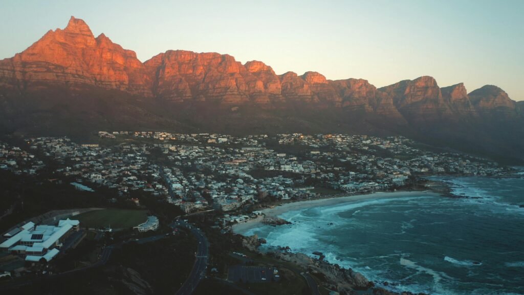 A breathtaking view of Cape Town's coastline with the iconic Twelve Apostles mountain range at sunset.