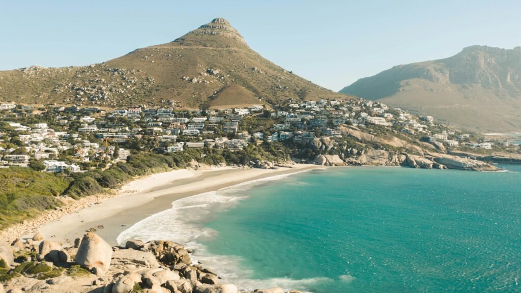 A breathtaking aerial view of Cape Town's coastline with mountains and turquoise sea.